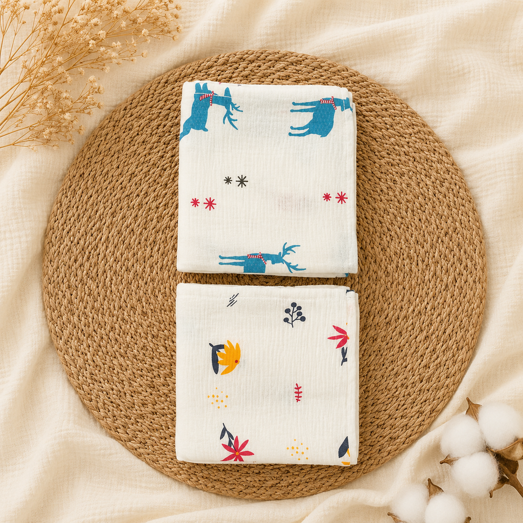 Two folded white baby cloths with blue deer and small bird prints